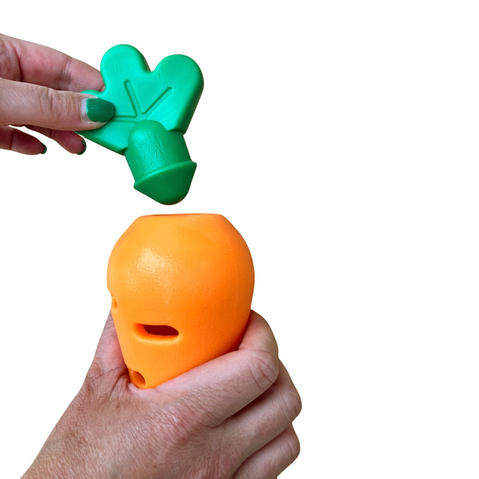 Hand holding and removing lid of makspatch carrot toy